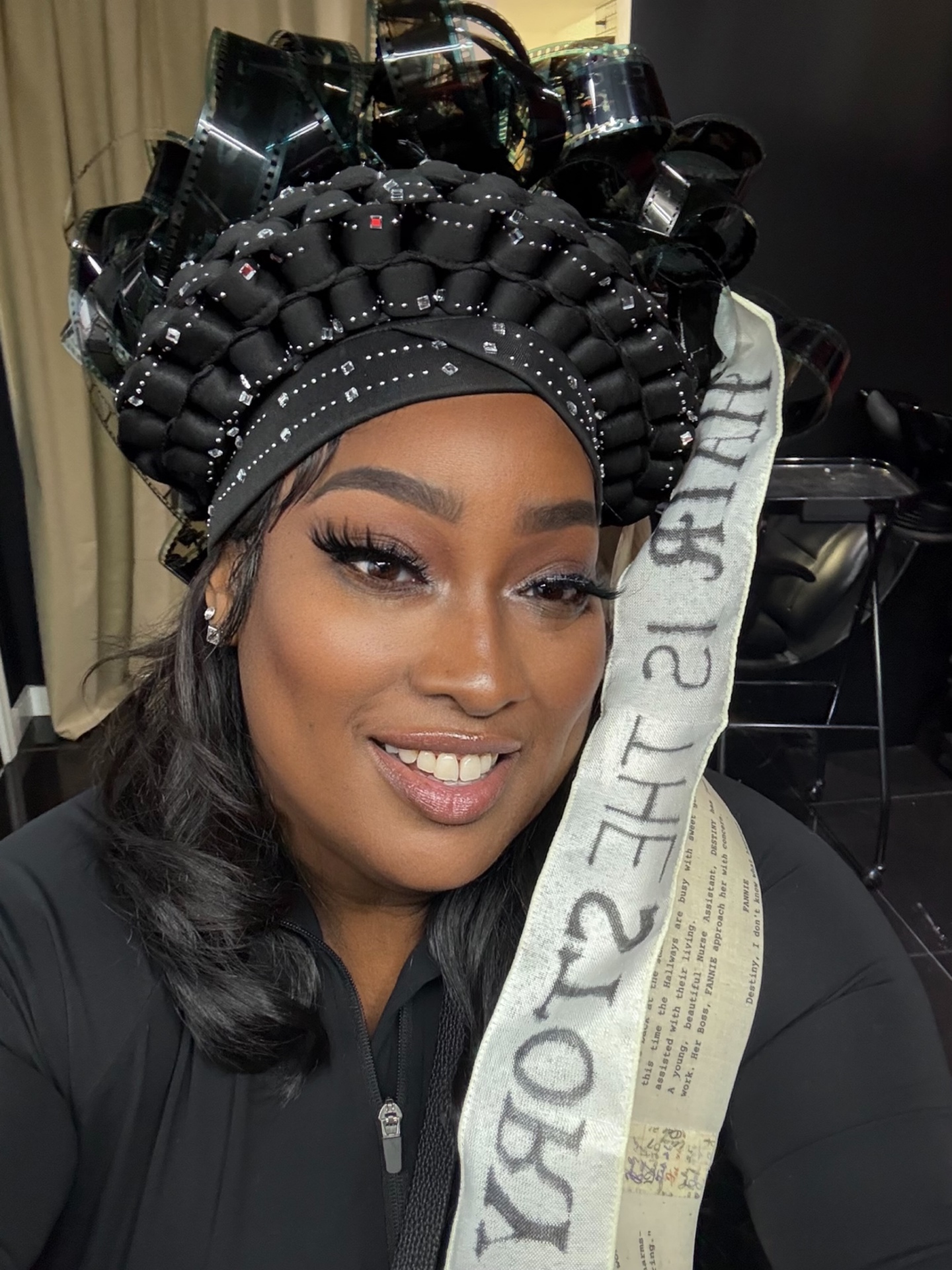 Portrait wearing a film-reel crown and a script-printed sash — Echoes in Digital.